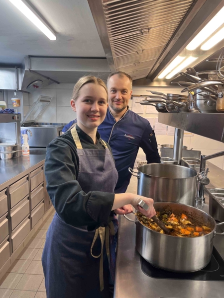 Mädchen mit Mitarbeiter am Suppekochen