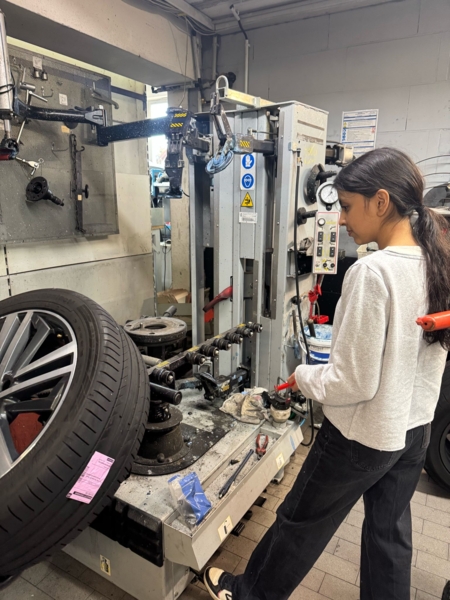 Mädchen schraubt in Kfz-Werkstatt