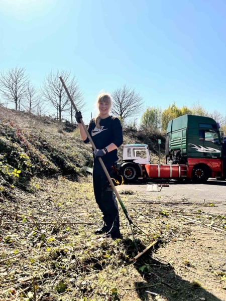 Mädchen beim Zusammenharken von Pfanzenteilen