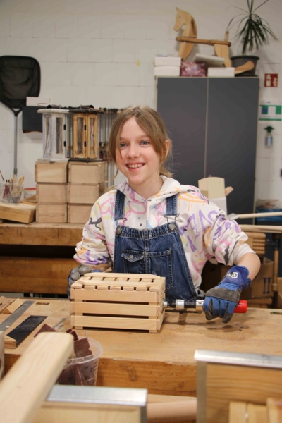 Mädchen mit Holzkasten und Schraubzwinge