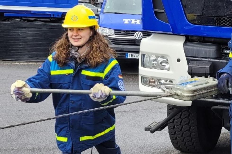 Mädchen bedient eine Winde an einem LKW.