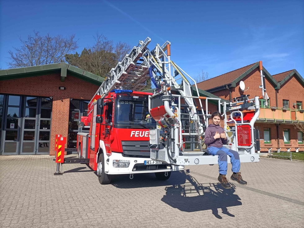 Mädchen mit Daumen hoch auf Feuerwehkorb