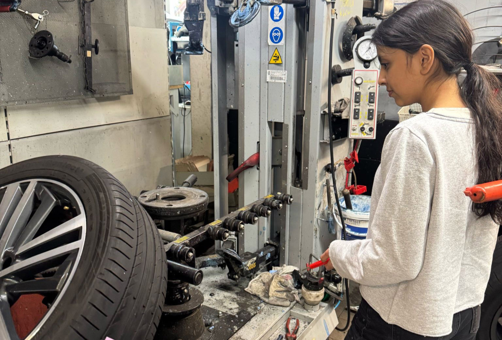 Mädchen schraubt in Kfz-Werkstatt