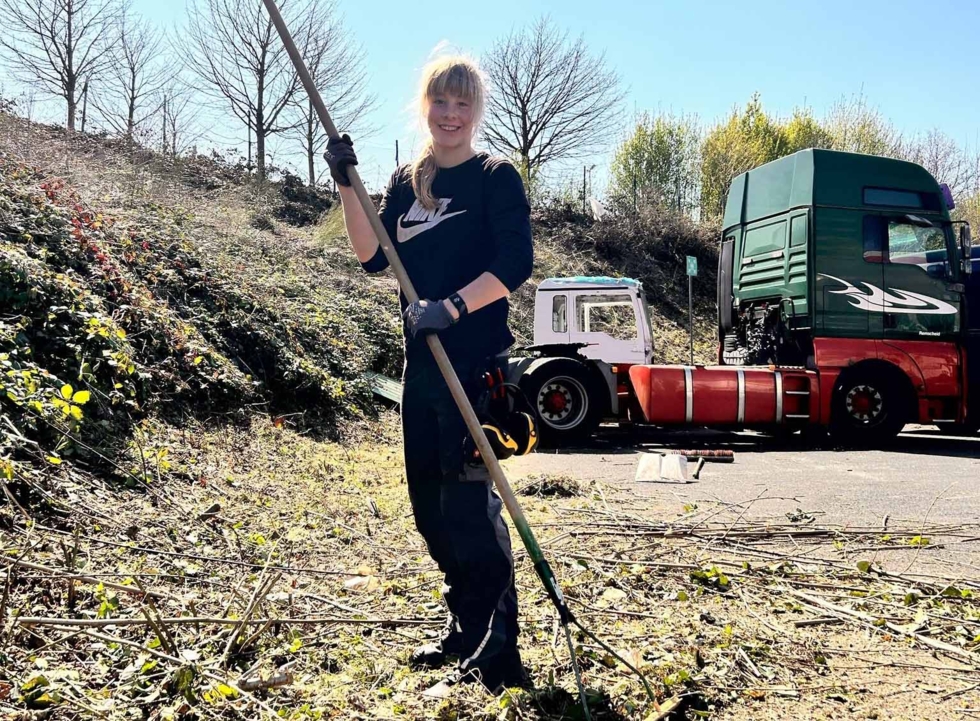 Mädchen beim Zusammenharken von Pfanzenteilen